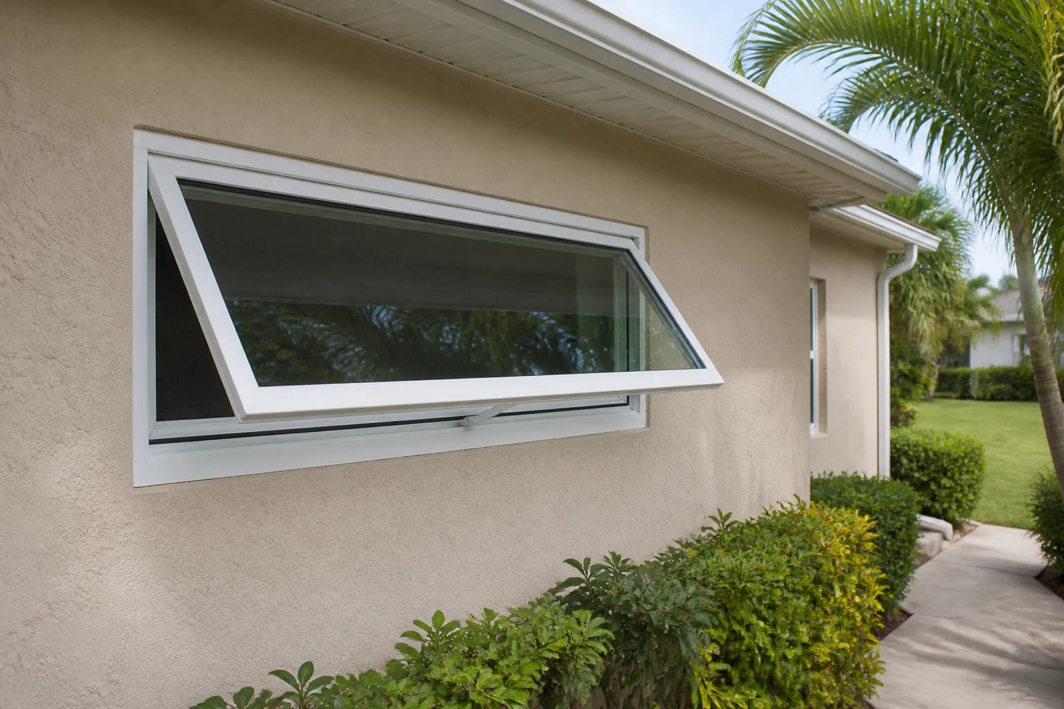 A white awning window projecting outward from a tan stucco Central Florida home