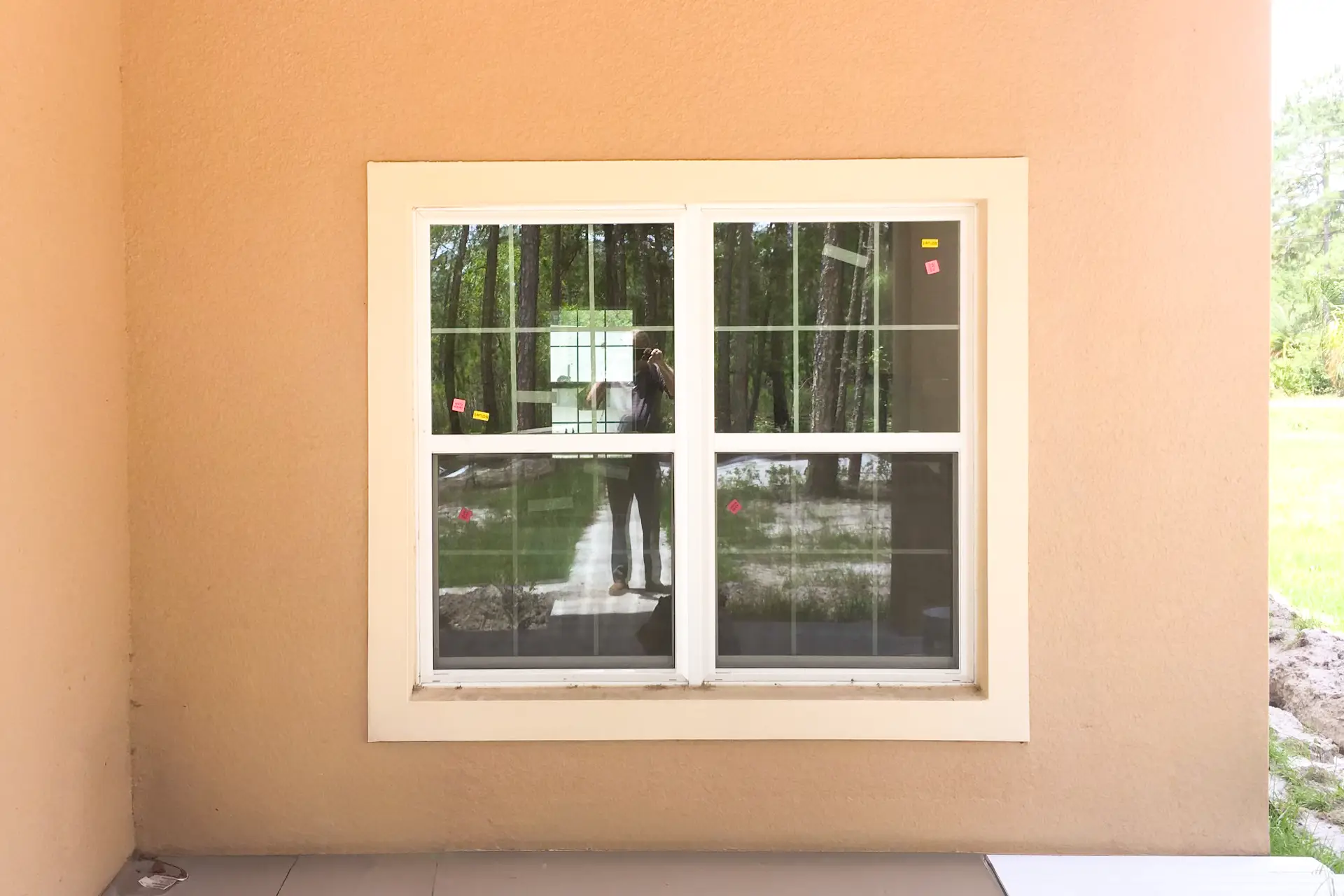 A white replacement window in a stucco wall on a Central Florida home